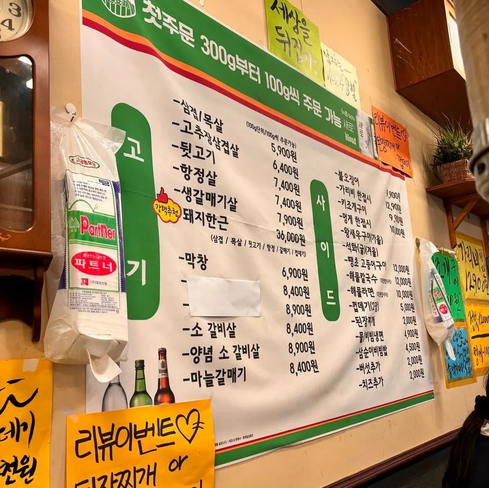 Menu board listing pork belly and seafood at Euljiro Yeontan Gui