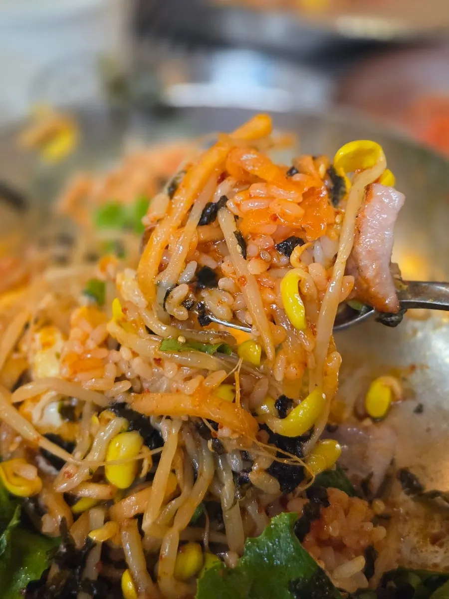 Bibimbap served in a large metal bowl