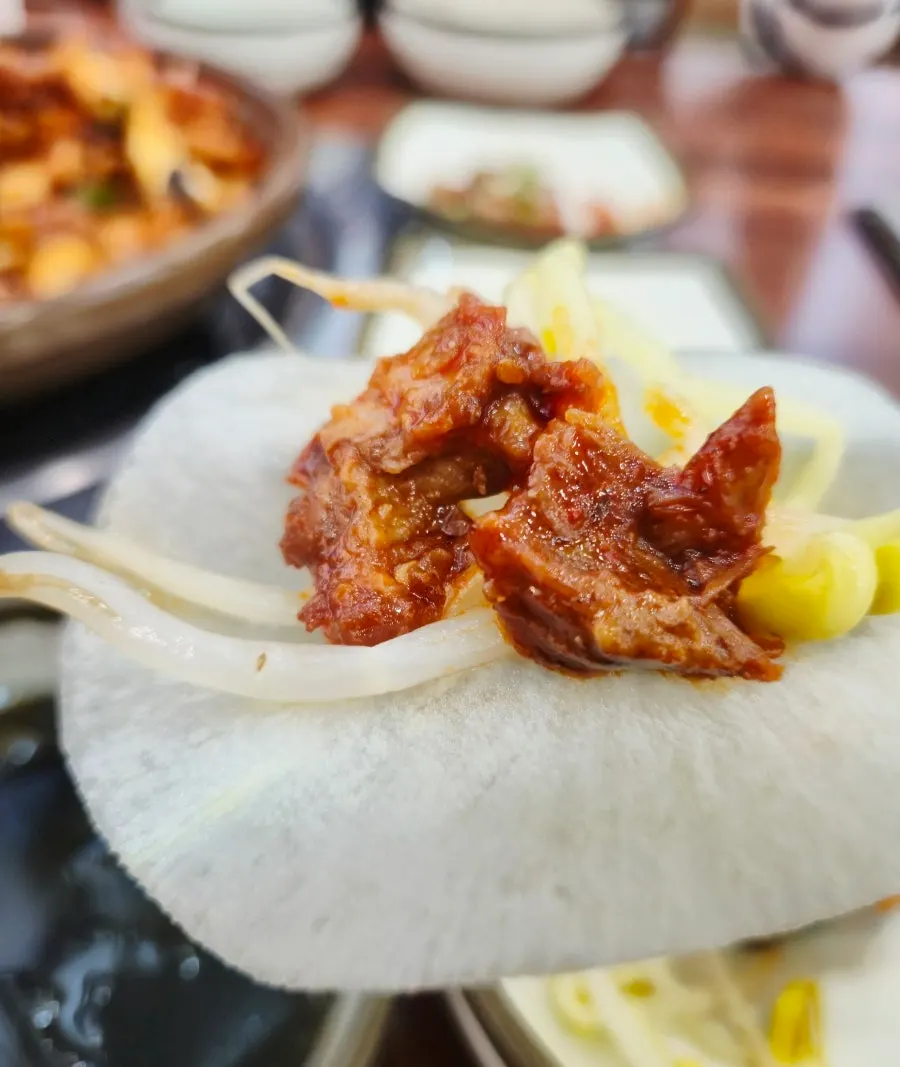 무쌈에 콩나물과 등갈비살을 올린 한 쌈
