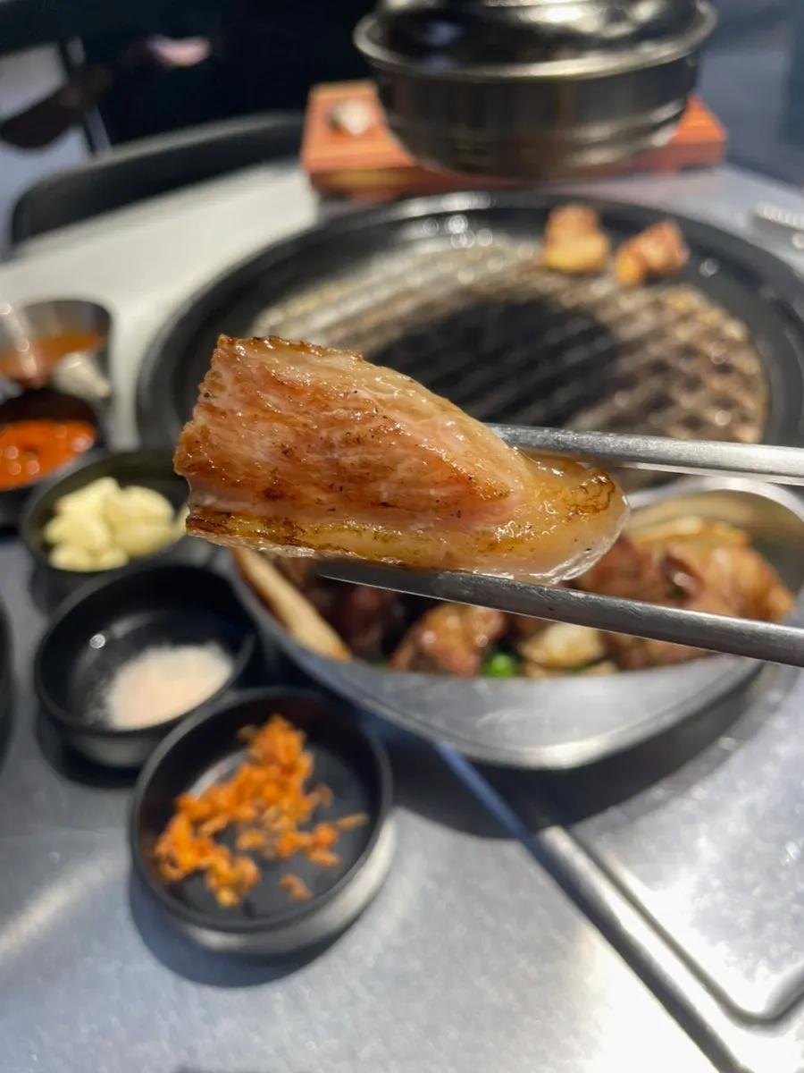 Pork being grilled by a staff member