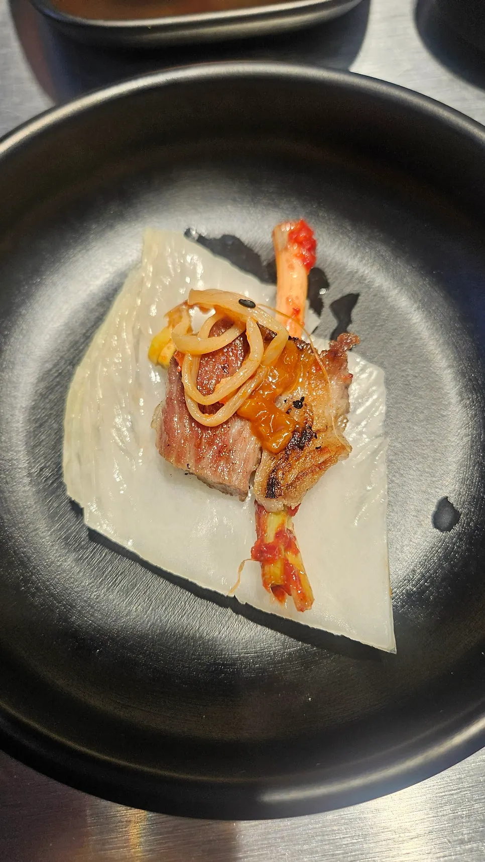 Guide showing the pink salt, salted shrimp, anchovy sauce, baek-kimchi eating order
