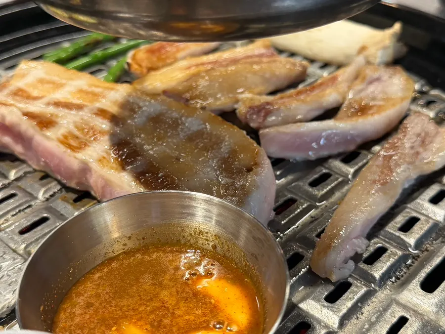 Whole pork belly grilling on the tabletop grill