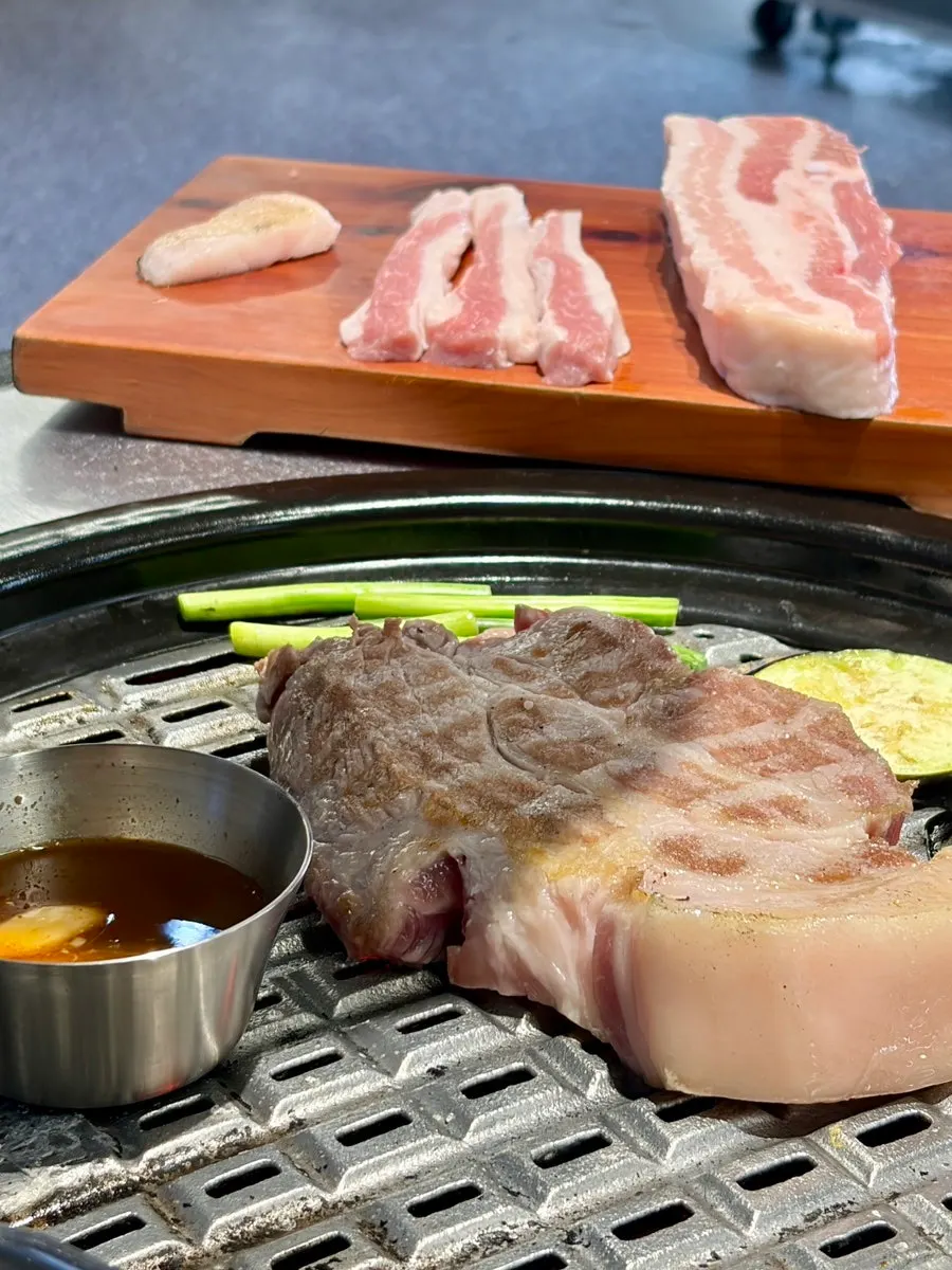 Staff member grilling the meat tableside