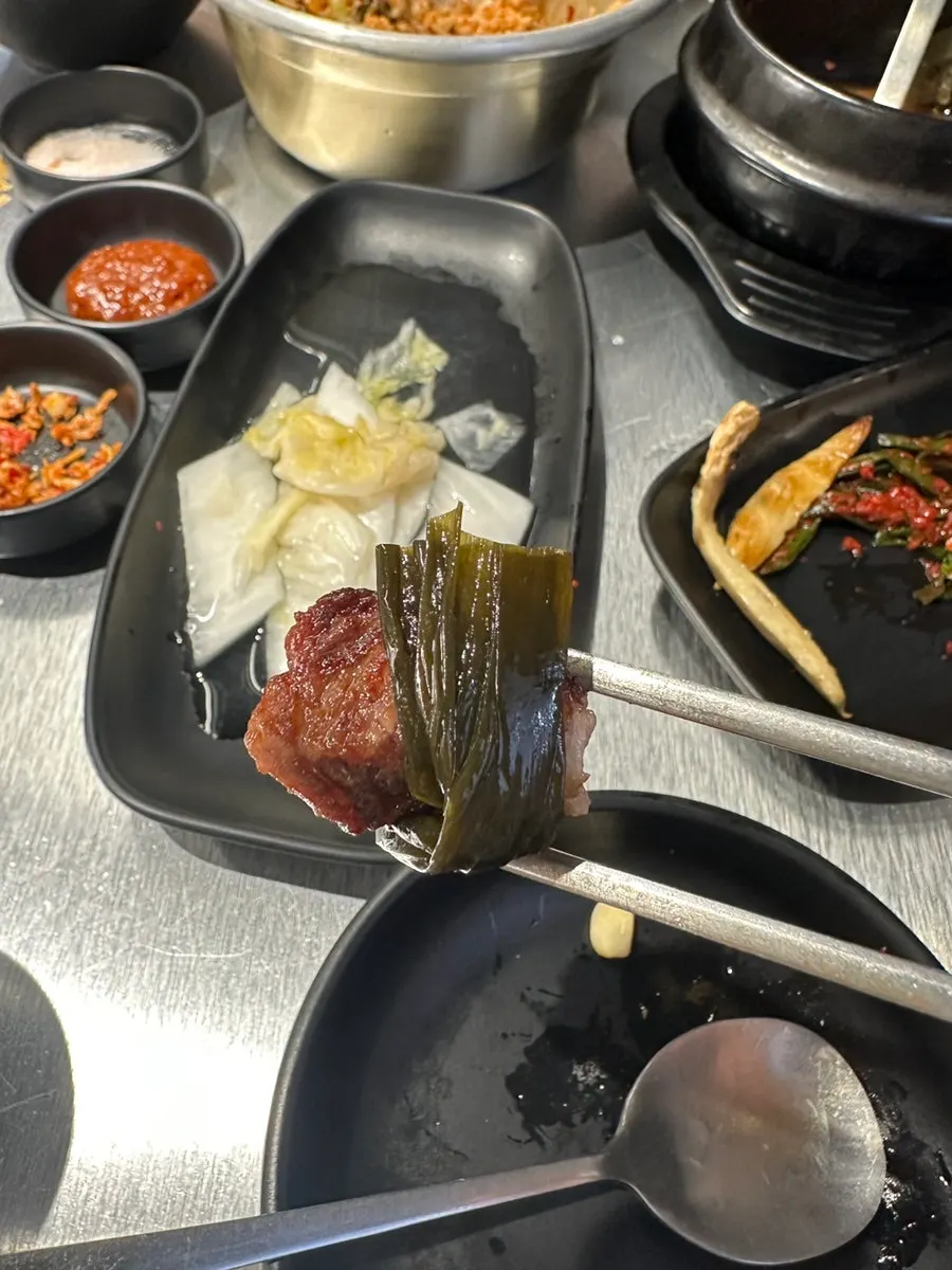 명이나물에 올린 삼겹살 한 점