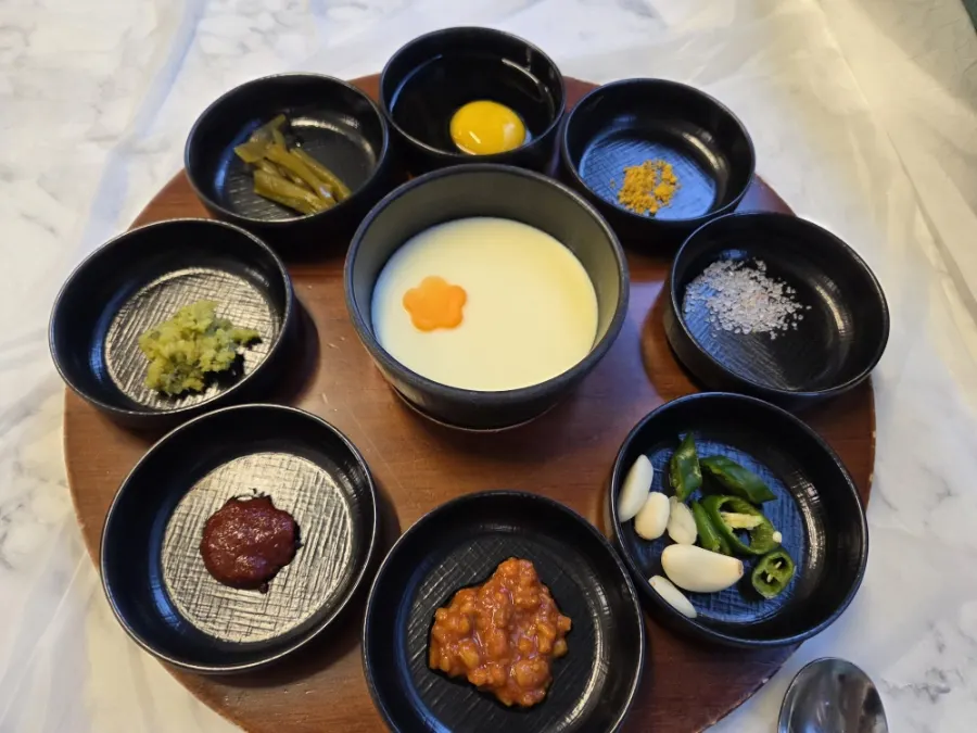 8가지 소스와 가운데 계란찜이 놓인 불판