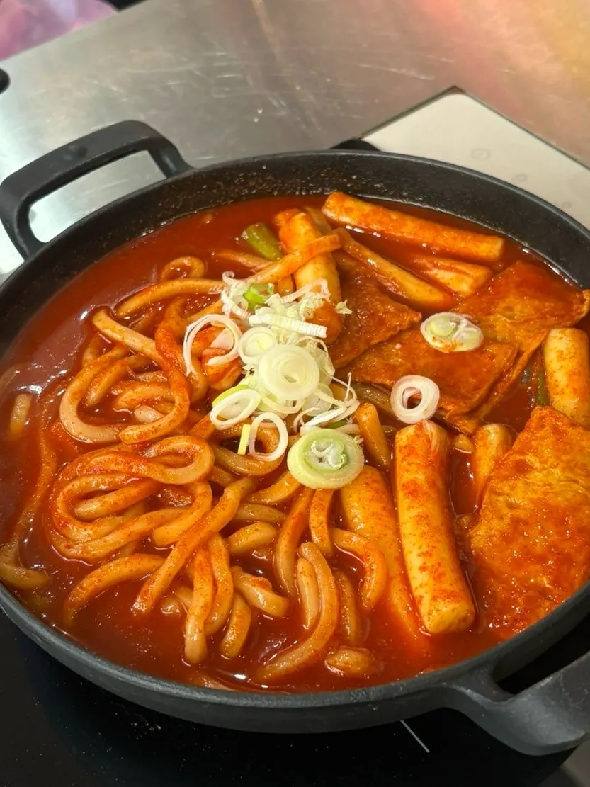 Sundae dipped into tteokbokki sauce