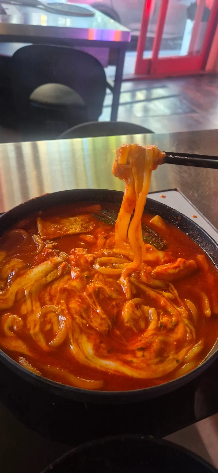 Cheese tteokbokki stretching over the induction burner