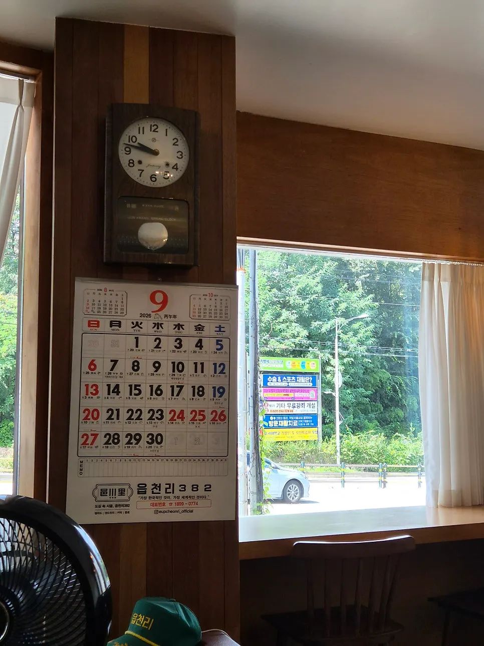 Wood-toned café interior with a wall clock and calendar