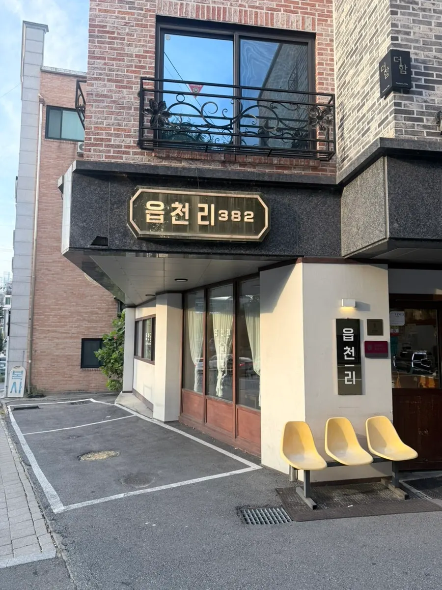 Brown signboard on the ground floor of the red brick building