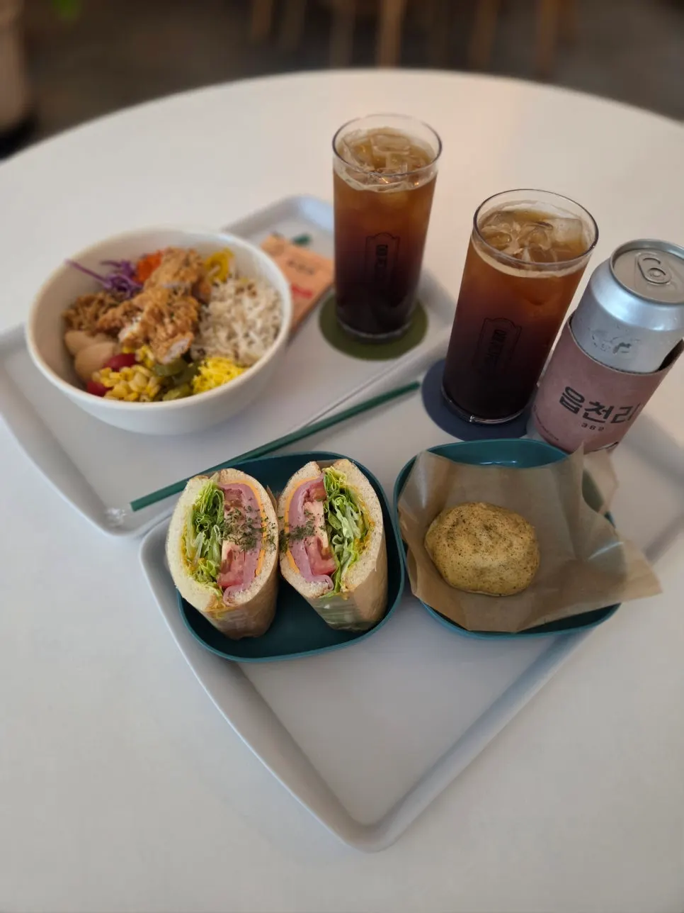 Table with poke, sandwich, and iced Americano