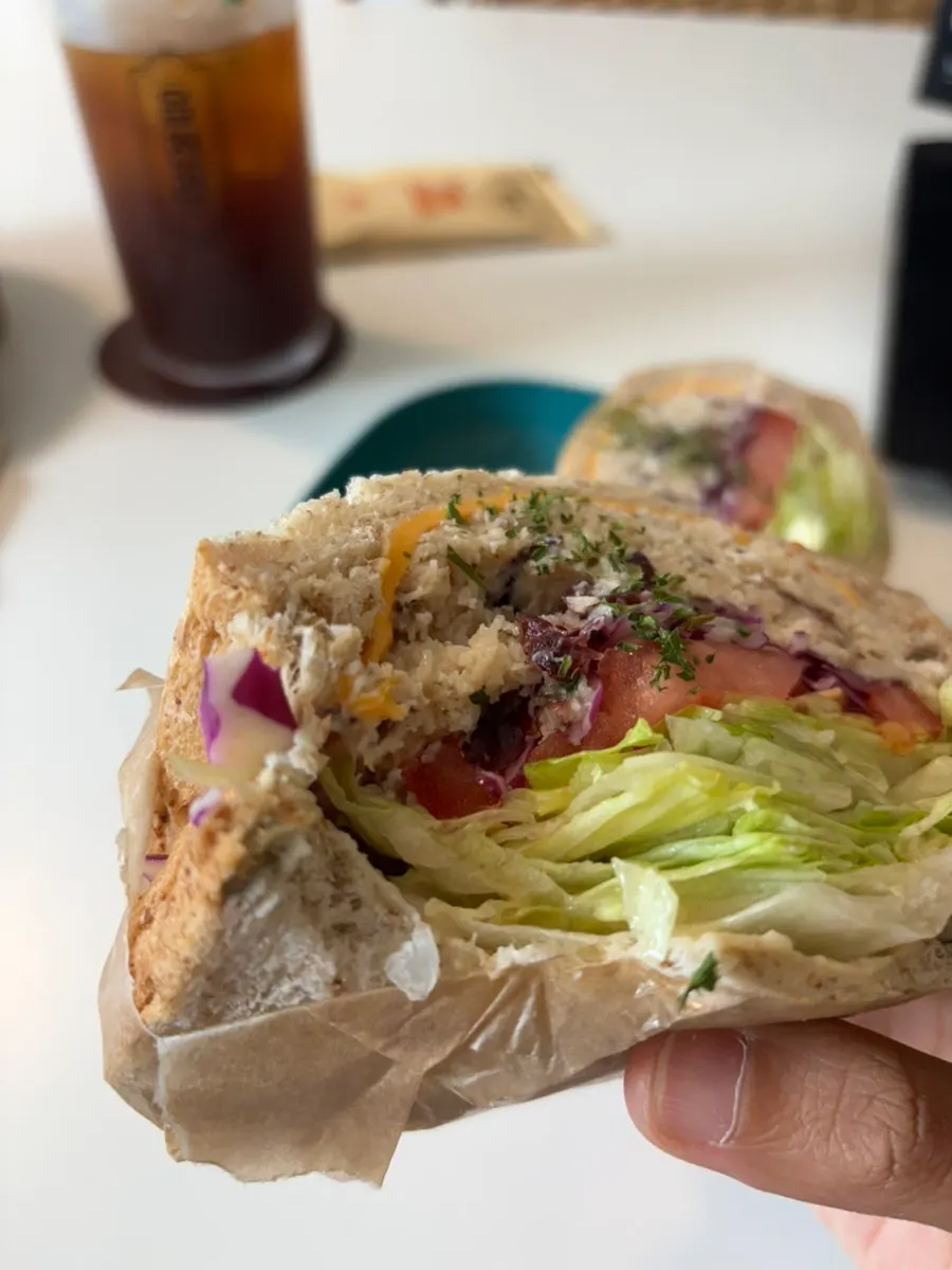 Cross-section of rye bread chicken breast sandwich packed with lettuce