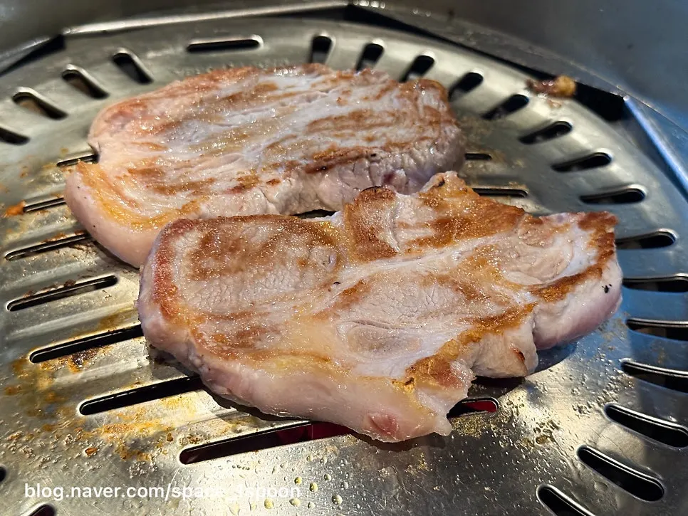 Pork neck browning nicely over the charcoal grill