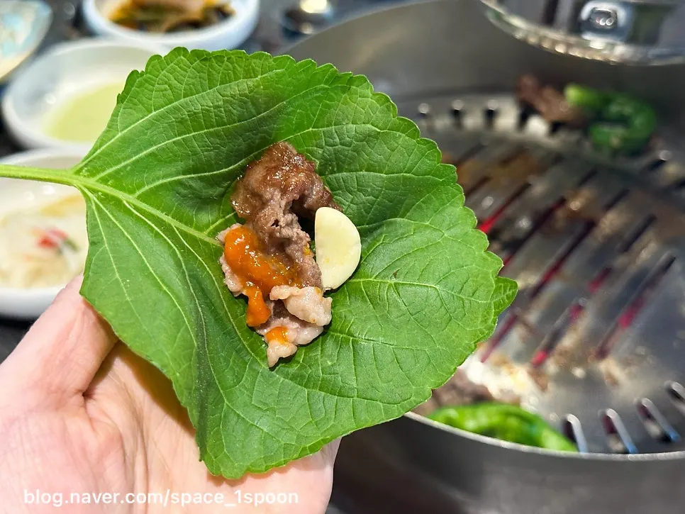 Thin slices of hanwoo beef brisket grilling over charcoal