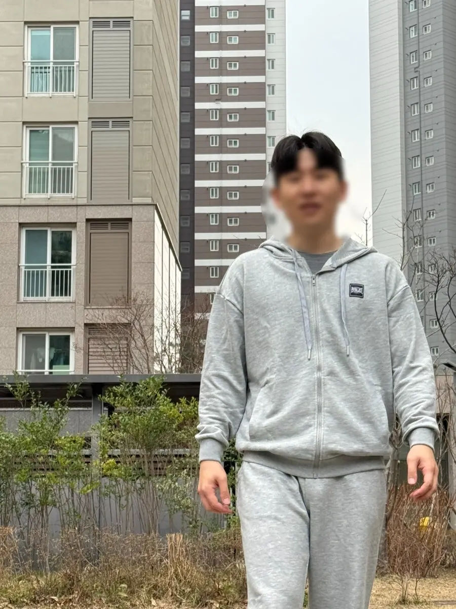 Gray hooded zip-up and training pants worn together