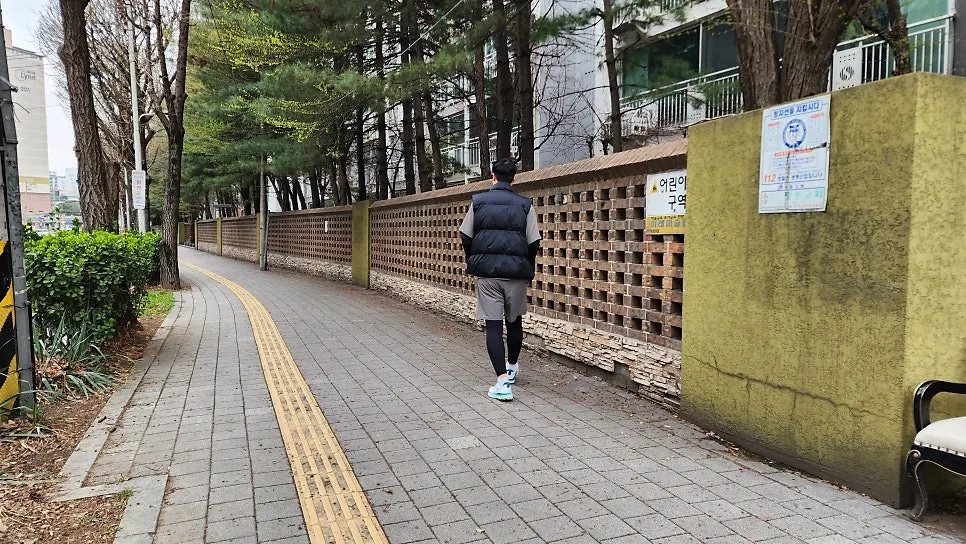 A vest layered over running wear on a chilly day