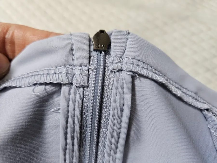 Front and zipper detail of the ash blue running jacket