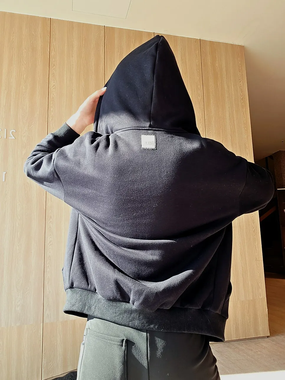 Black hoodie zip-up with a front logo