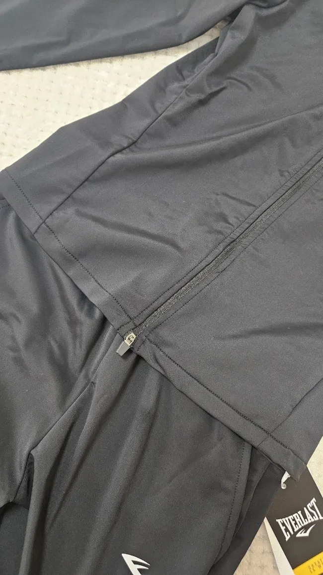 Black running jacket and bootcut pants worn