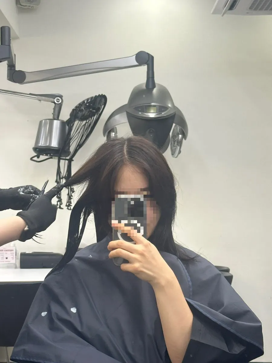 레이어드 펌 전 가벼운 커트를 진행하는 모습