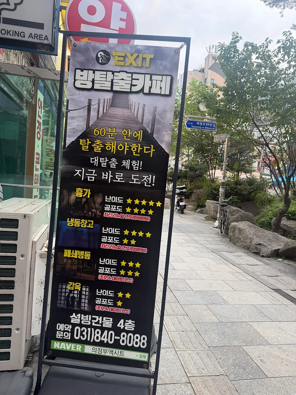 Sign at the 1st floor entrance listing the escape room themes