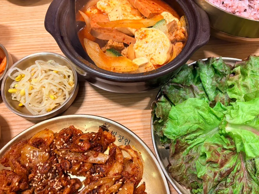 A full table with jjaglie stew and bulgogi served together