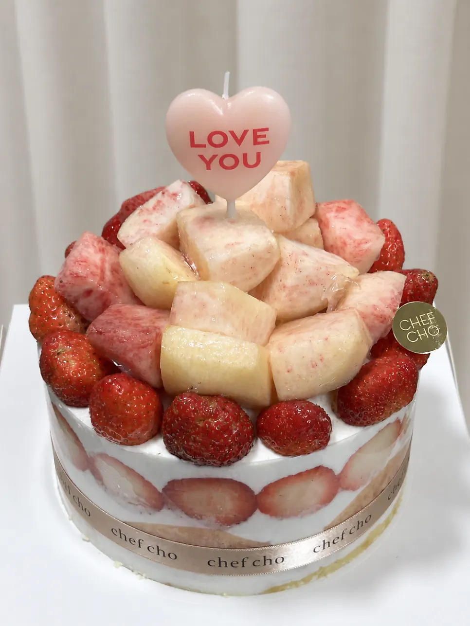 Cake topped with strawberries and peaches