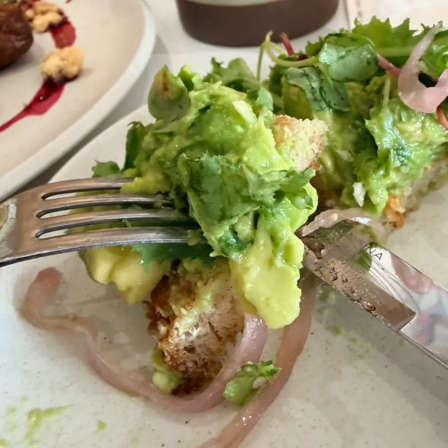 A plate of avocado toast served with vegetables