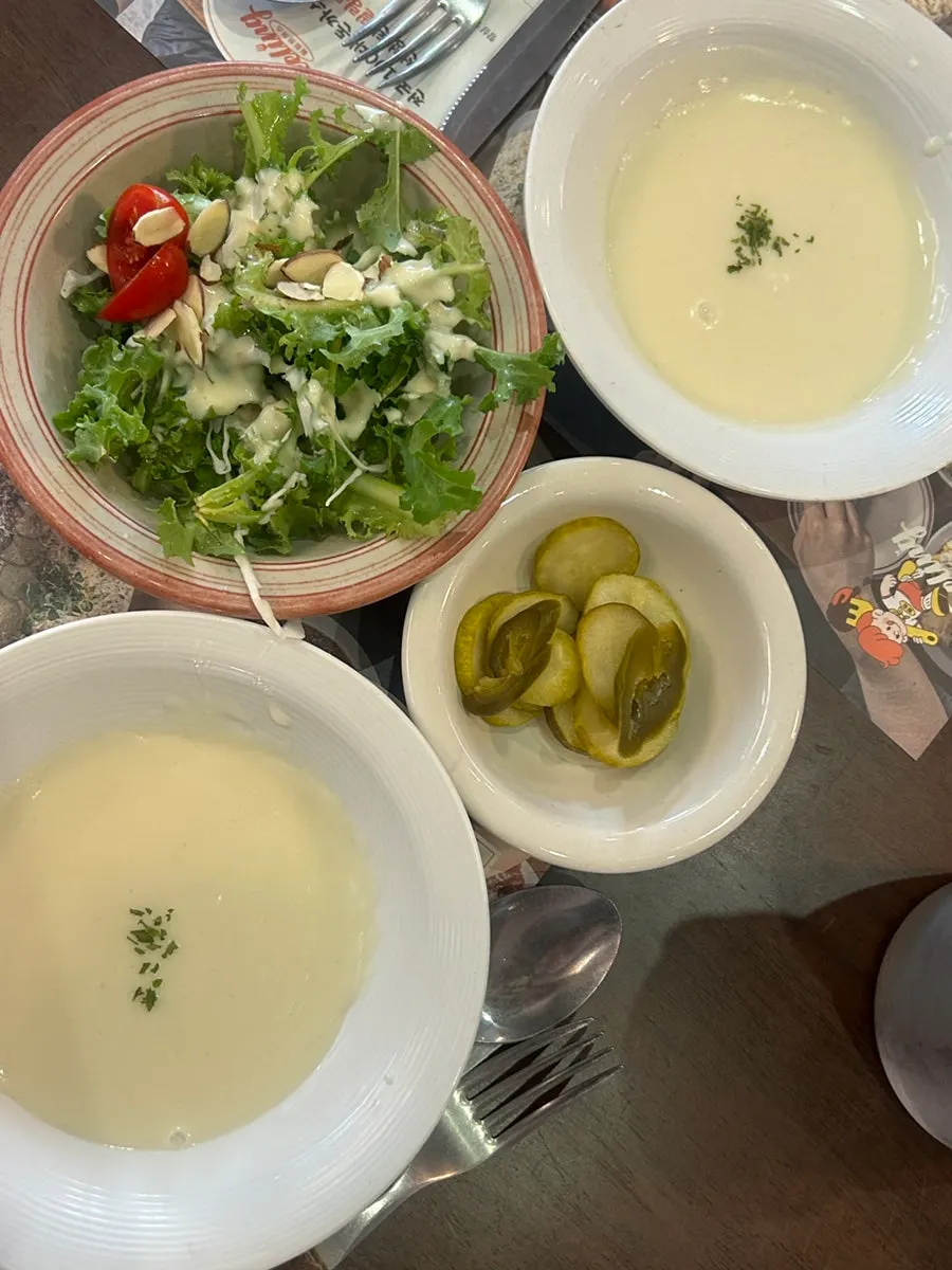 Table setting with pickles, salad, and soup served as basics