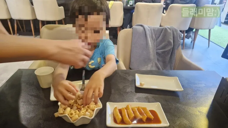 A child playing with ppeongtwigi and chicken tongs
