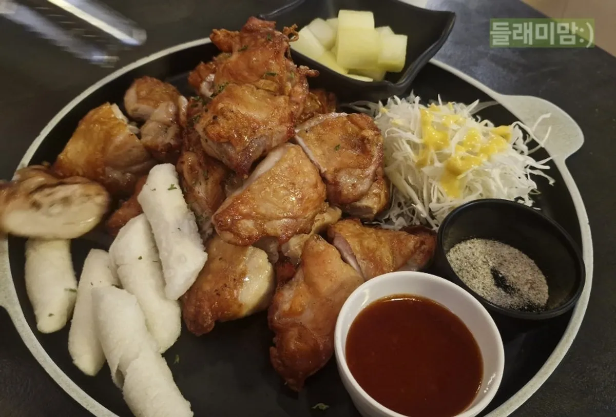 Plate of oven-baked boneless chicken with fried rice cake and salad