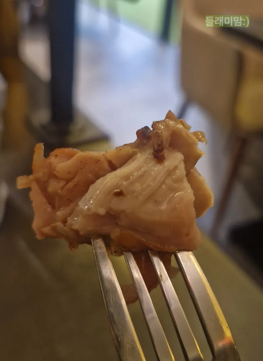 A hand picking up a piece of boneless thigh meat chicken