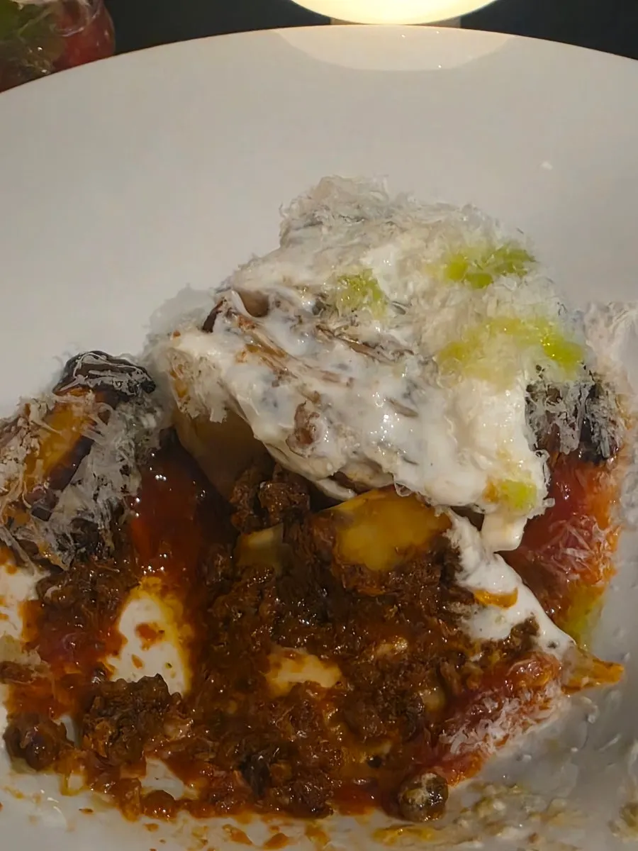 Cross-section of mille-feuille lasagna over tomato sauce