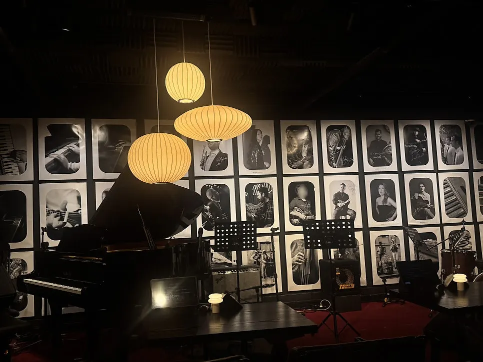 Sofa seating area with black-and-white jazz artist portraits on the wall