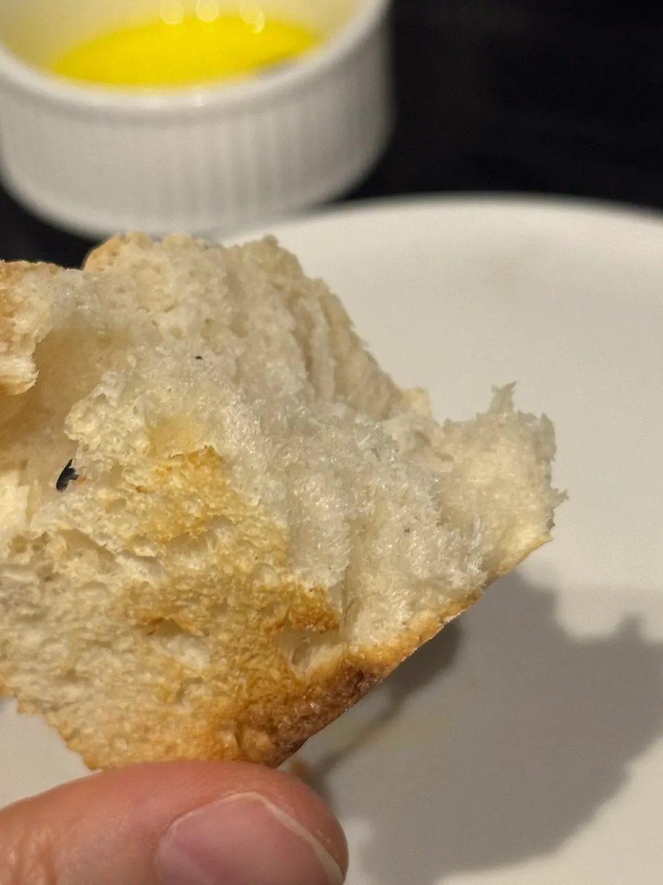 Close-up of crispy potato topped with basil and mayo sauce