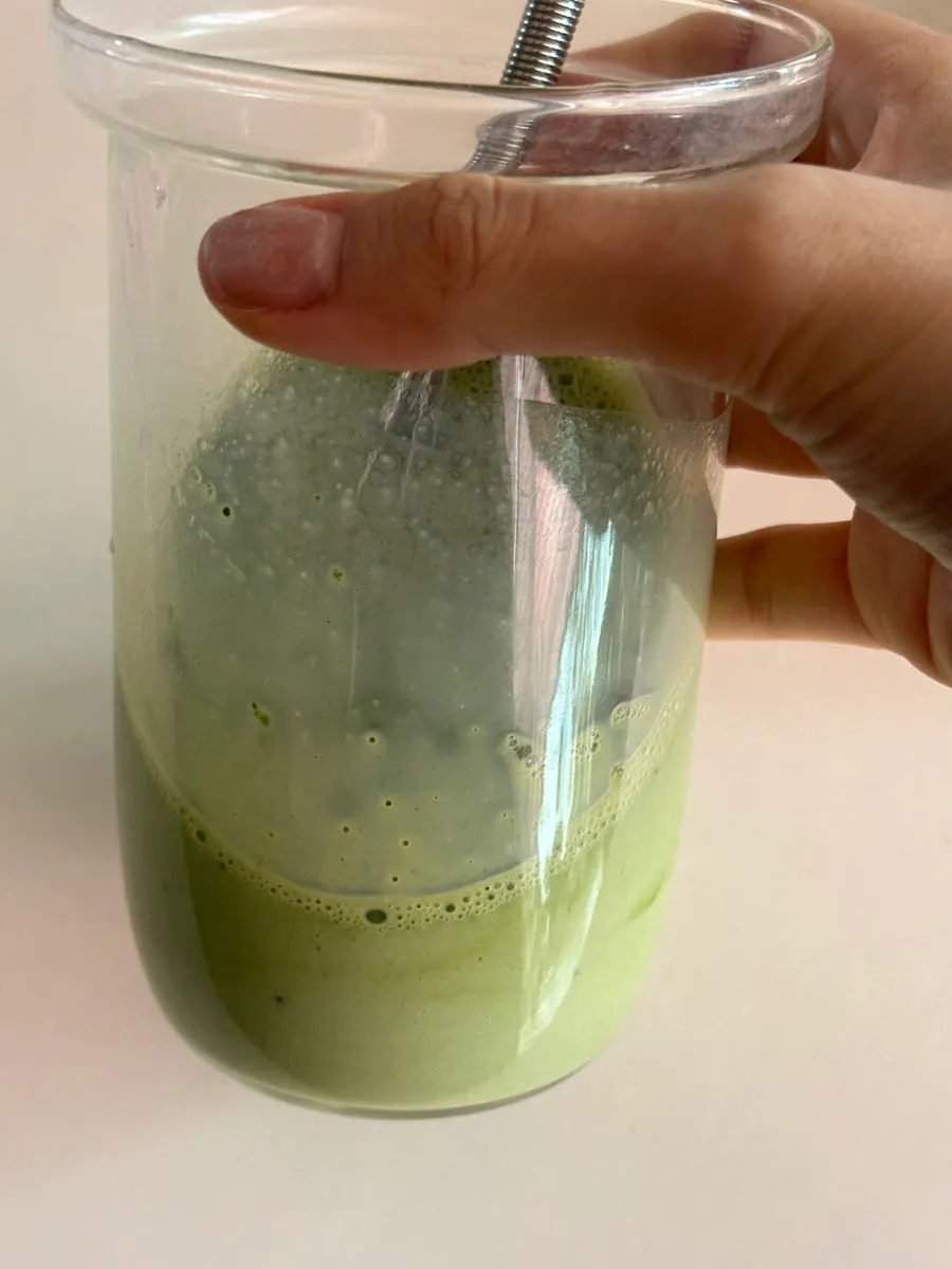 Green juice made by mixing curly kale powder into water