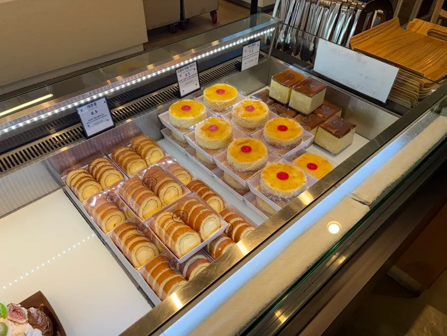 Desserts including tiramisu and roll cake on display