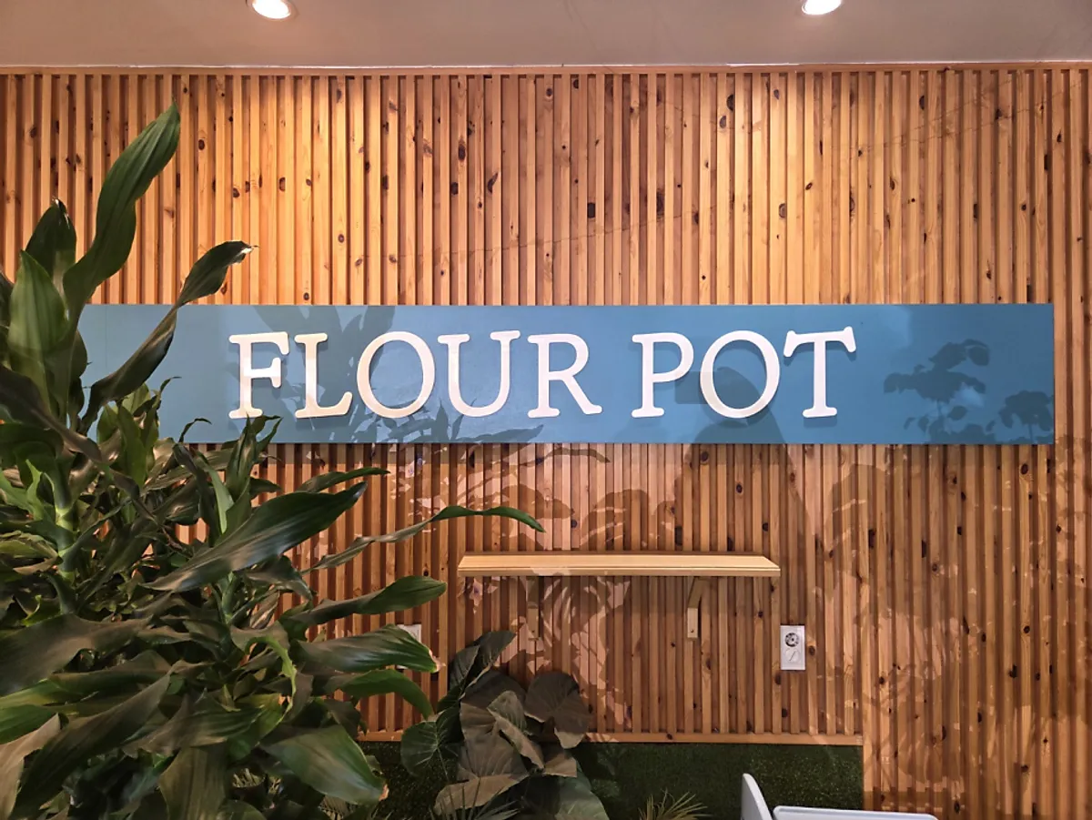 Full view of Flowerpot Cafe & Bakery surrounded by green nature