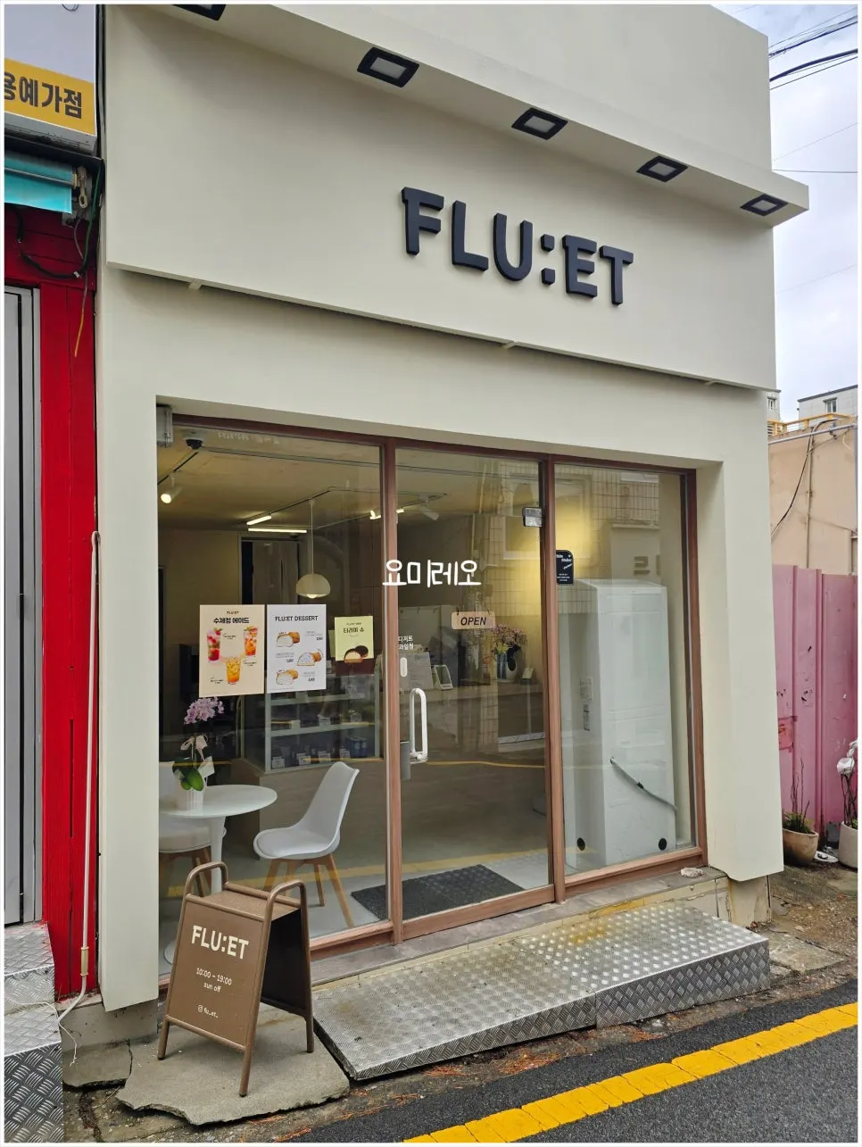아이보리 외벽과 FLU:ET 입체 간판이 걸린 파사드