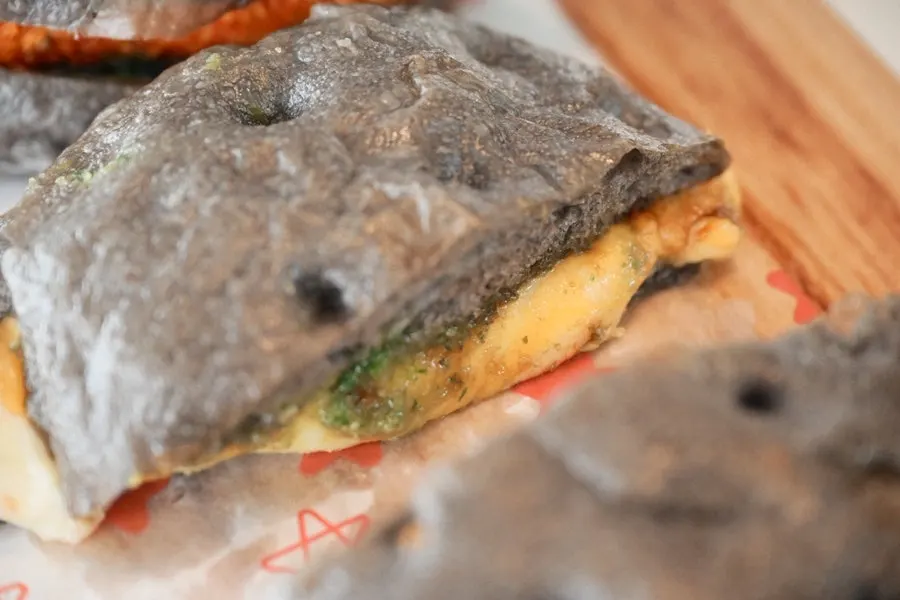 Genovese pizza topped with basil pesto and arugula