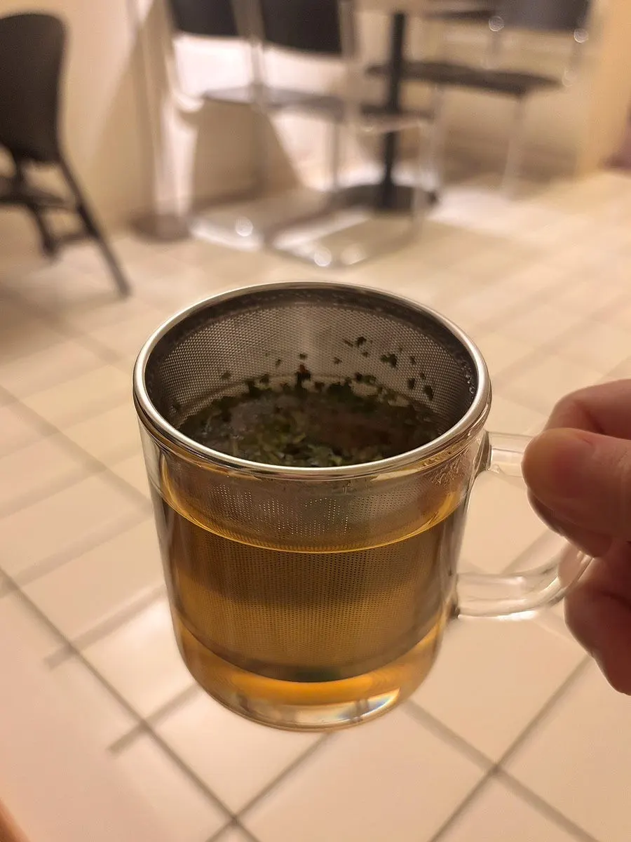Teapot of peppermint tea with generous tea leaves