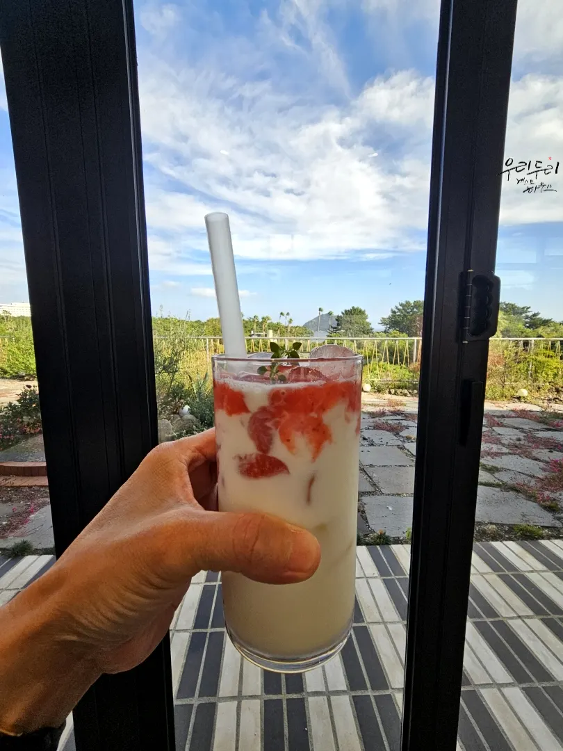 A glass of strawberry latte made with blended strawberry flesh