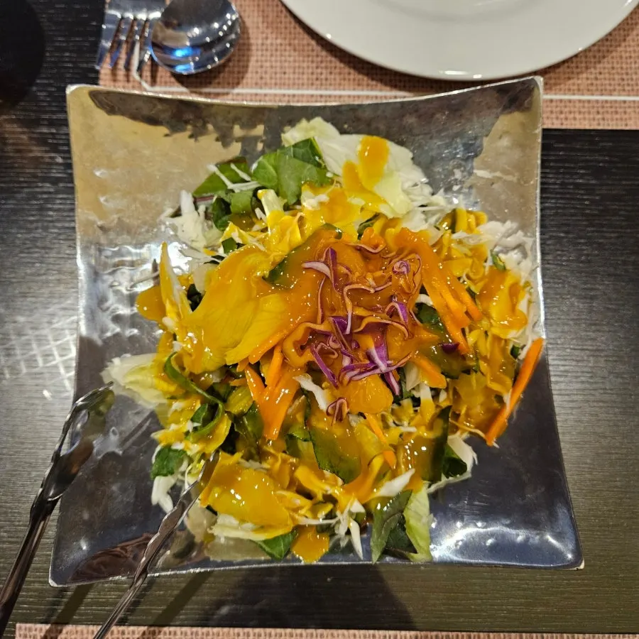Green salad drizzled with an orange sauce