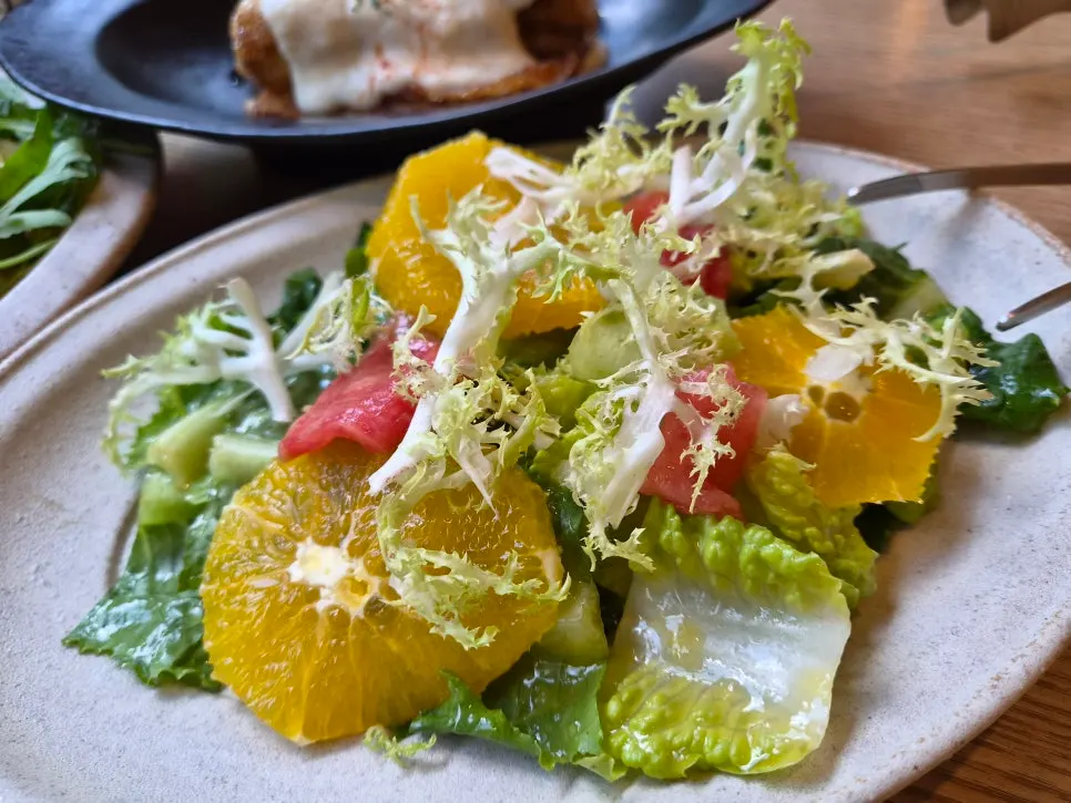 Fresh salad topped with seasonal fruit