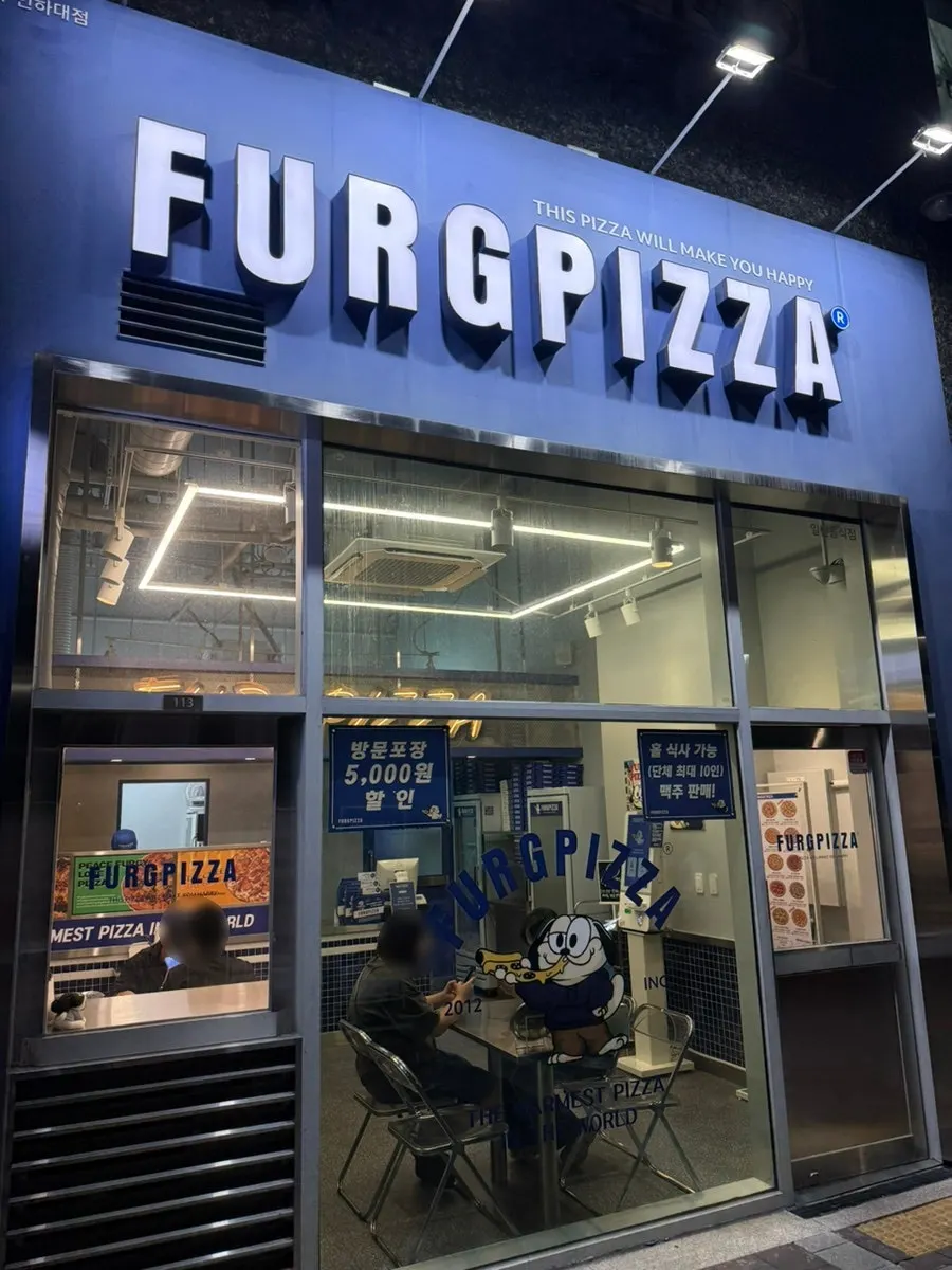 青いFURGPIZZAの看板が掛かったフォーグピザ仁荷大駅店の外観