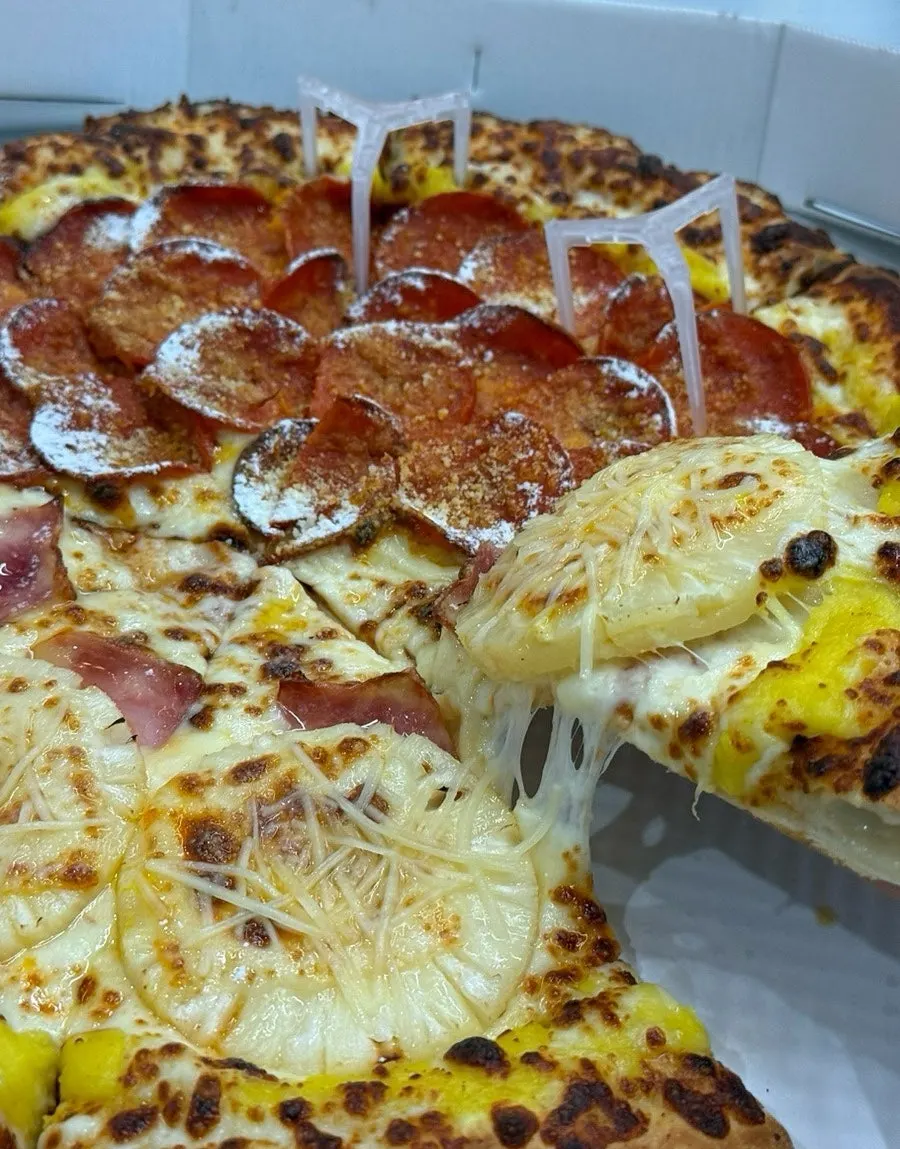パイナップルとチーズの組み合わせのハワイアンピザの一切れ