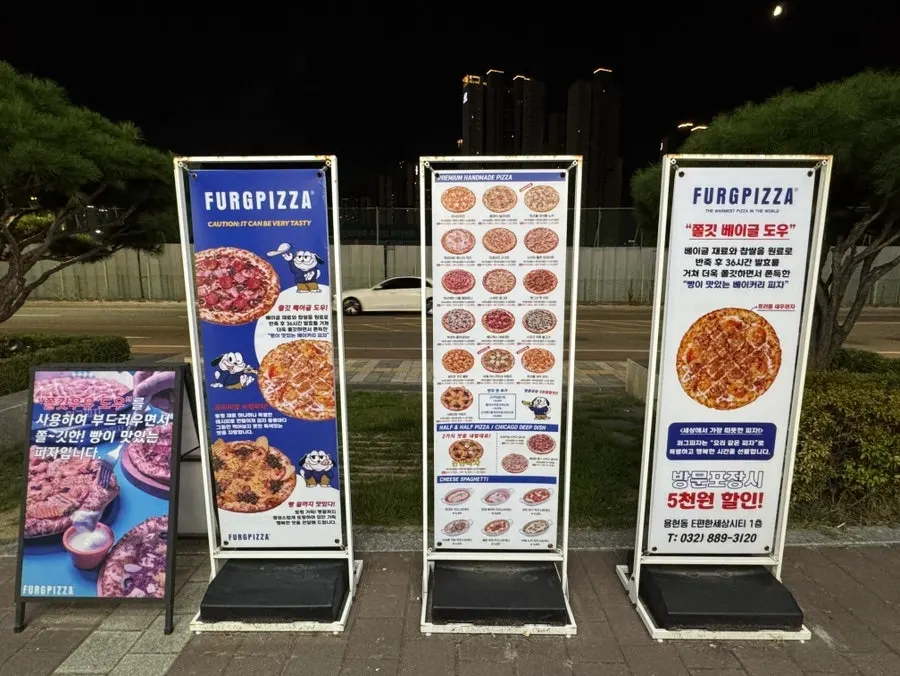 퍼그 캐릭터 포스터가 붙은 퍼그피자 매장 외벽