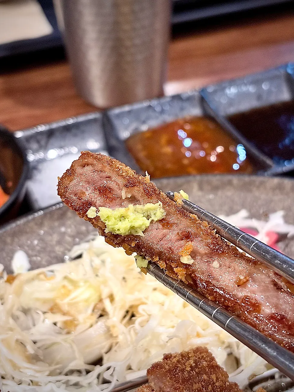 塩に付けて食べる牛カツの一切れ