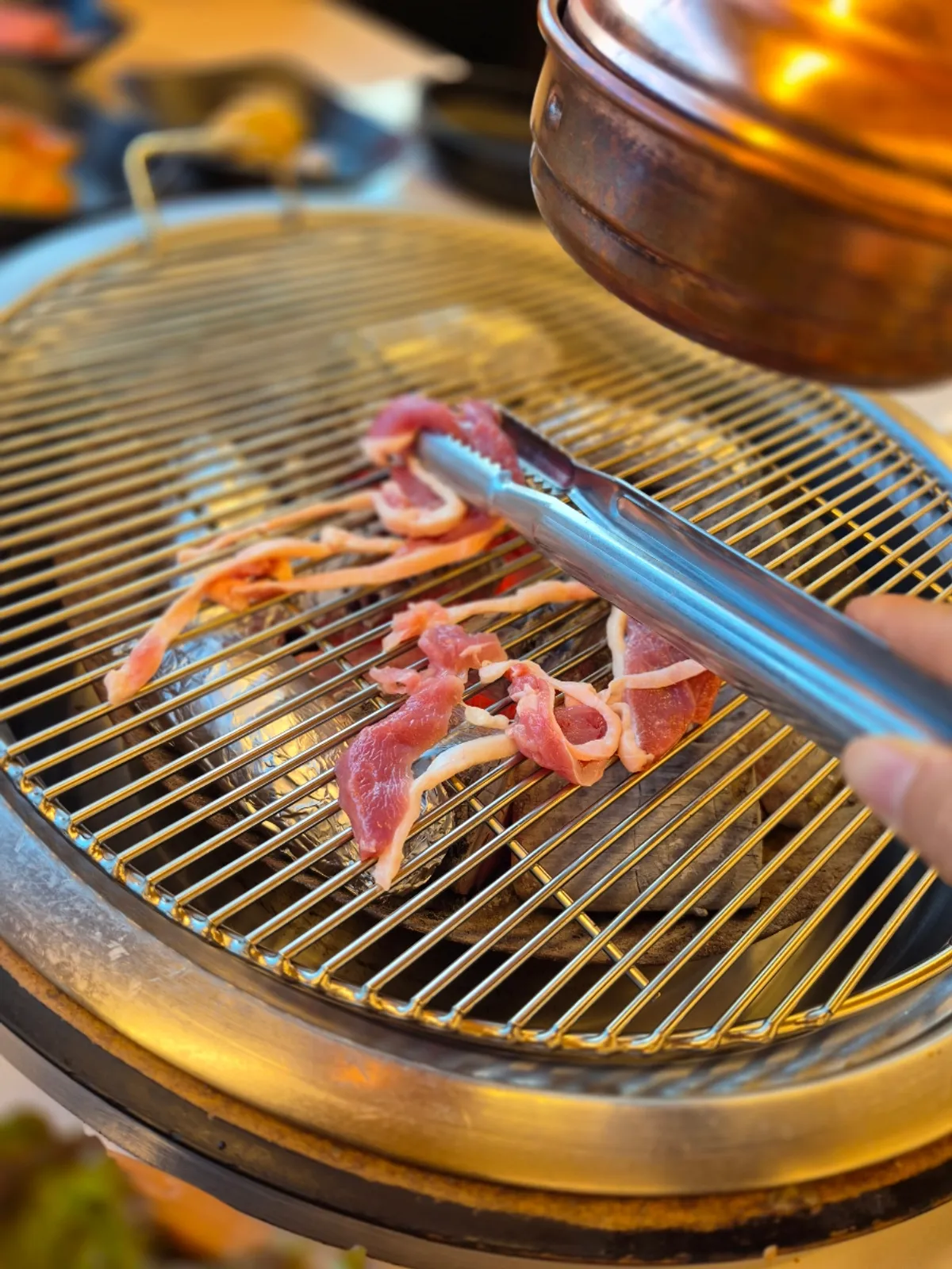 Raw duck cooking on the grill as duck fat renders out