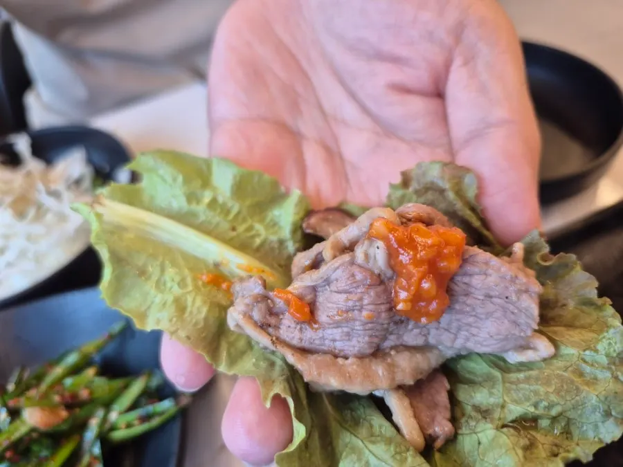 Table setting with lettuce wraps and bean sprouts alongside the duck