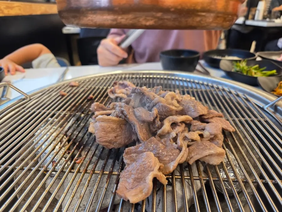 Fresh duck grilling to golden brown over charcoal